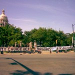Community Choice Act Now, Our Homes Not Nursing homes" reads the giant banner held in front of the Texas Capitol, at 11th and Congress.